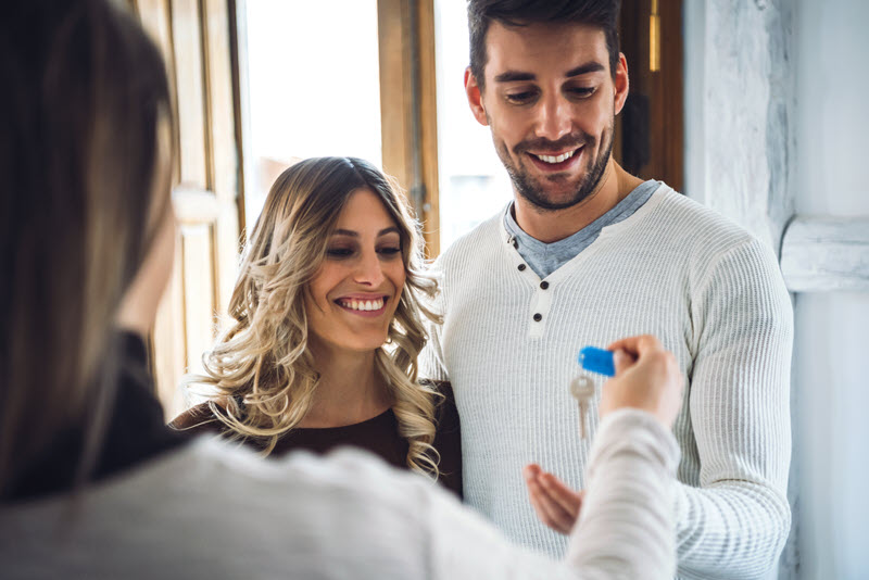 A couple receiving house keys from real estate agent